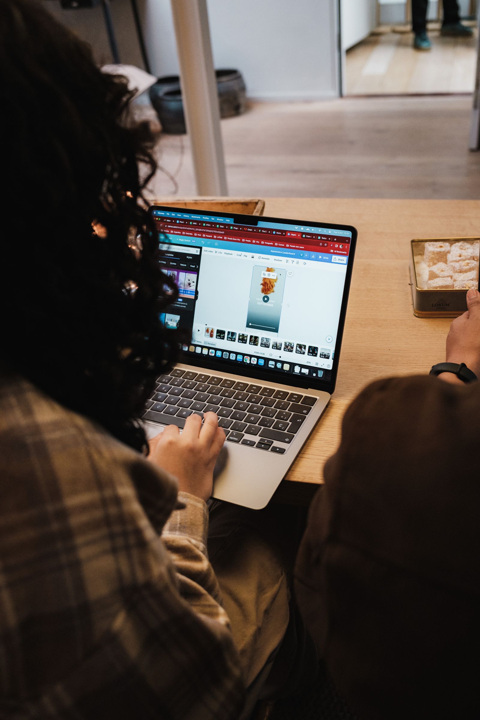 Woman working on a laptop from home, seen from behind
